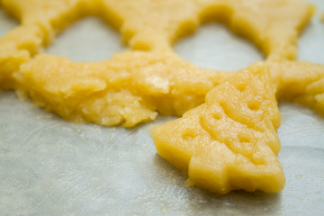 Raw dough for christmas cookies for children, making gingerbread in form of fir tree close-up. Recipe of New year treat. Homemade bakery, xmas sweet, winter holidays concept