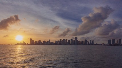 Skyline of downtown Miami from the sea under sky and clouds at sunset, in Florida, USA