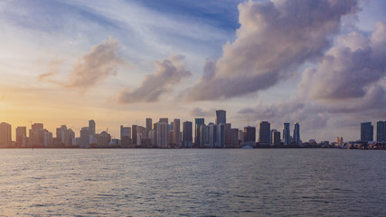 Skyline of downtown Miami from the sea under sky and clouds at sunset, in Florida, USA