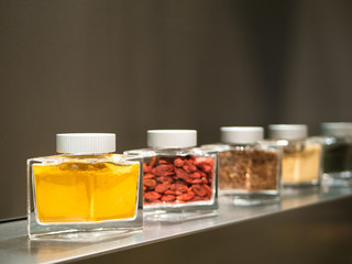 glasses of  curry and different spices and herbs standing on a kitchen shelf