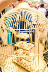 Fototapeta na wymiar Egg-shaped appetizers of bird served inside a luxury golden cage.