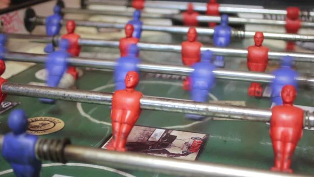 Close-up shot of people playing an old vintage game of fussball.
