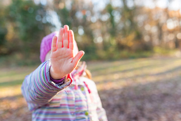 Little girl showing hand in stop gesture