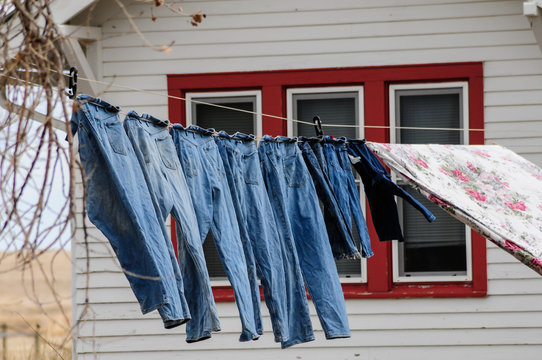 Blue jeans hanging on clothesline. Wind blowing.