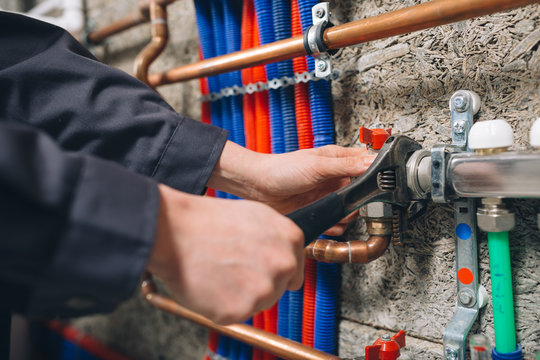 Hands Of Plumber Working In Boiler Room