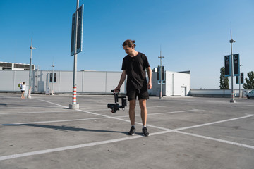Professional videographer holding camera on 3-axis gimbal. Videographer using steadicam. Pro equipment helps to make high quality video without shaking. © Volodymyr_sh