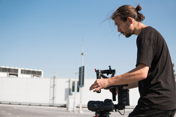 Professional videographer holding camera on 3-axis gimbal. Videographer using steadicam. Pro equipment helps to make high quality video without shaking. © Volodymyr_sh