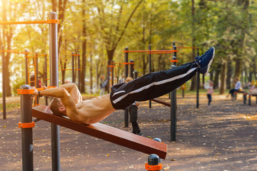 Athletic guy doing gymnastics outdoor