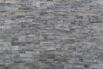 Fototapeta premium Gray slate wall stone background. horizontal modern brick wall for wallpaper and background.