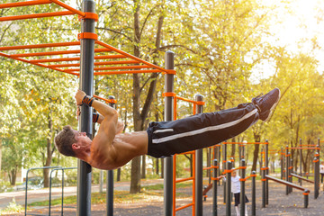 Athletic guy doing gymnastics outdoor