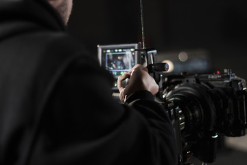 Professional videographer holding camera mounted on easy rig. Videographer using steadicam. Pro...