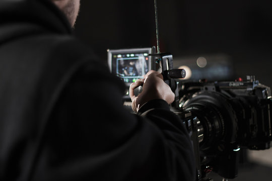 Professional videographer holding camera mounted on easy rig. Videographer using steadicam. Pro equipment helps to make high quality video without shaking.