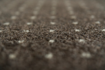 Brown carpet with a white dots texture. Indoor carpeting shoot in daylight.