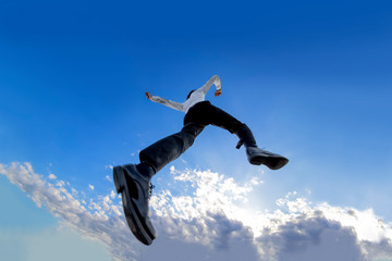 Fototapeta na wymiar 青空をバックにジャンプするYシャツ姿の若いビジネスマン1人。元気・パワー・成功・挑戦イメージ