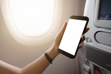 Touching and slide mobile phone screen on airplane or aircraft,blank mobile phone screen mock up,selective focus