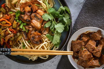 Traditional Chinese noodles noodles with fried mushrooms and meat. Close-up. Top view