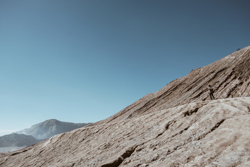 Man on top of Layer Volcanic ash as sand ground of Mount Bromo volcano (Gunung Bromo) at Bromo Tengger Semeru National Park, East Java, Indonesia.