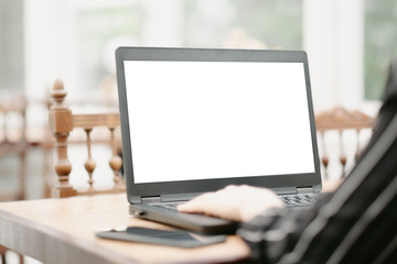 close-up woman hand typing keyboard computer showing white screen in coffee shop