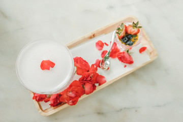 fruits cocktail and Panna cotta with rasperry and mint topping with strawberry sauce and rose petal on the white luxury table with a perfect fog from dry ice. Dessert Party