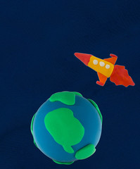 Plasticine blue and green Planet and rocket flying