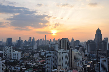 The sunset of Bangkok, Thailand cityscape skyline. Bangkok is the metropolis for tourists around the world. The city located between high buildings & local small houses. This photo taken from rooftop.