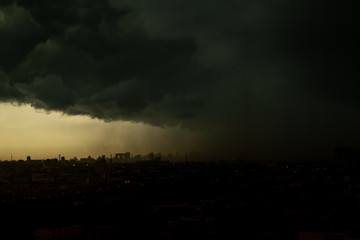Dark storm clouds over cityscape.