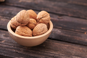 Walnuts on dark vintage table, Walnuts kernels in wooden bowl. Walnut healthy food
