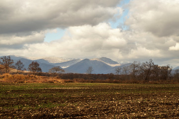 autumn field at the foot of the mountains