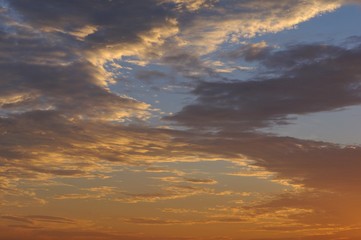 The sunset sky background with dark clouds and sunlight for the dusk moment in the evening.