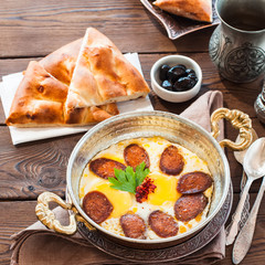 Turkish breakfast  - fried eggs with sausages and spices in a pa