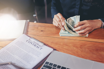 Naklejka premium Businesswoman counting dollars money for deal and make contract in business meeting.