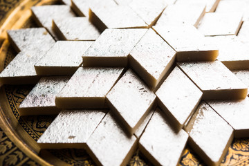 Kaju Katli is a Diamond shape Indian sweet made using cashew sugar and mava, served in a plate or...