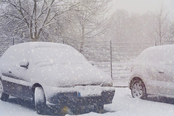 Winter, Schnee und verschneite Autos auf einem Parkplatz