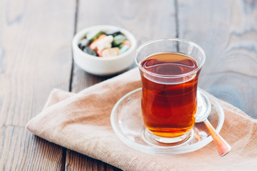 Turkish tea in authentic glass cup with delights. Closu up.