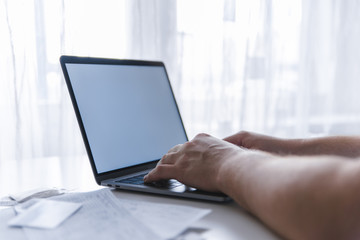 man hands typing on keyboard. laptop with white screen. laptop looks like macbook
