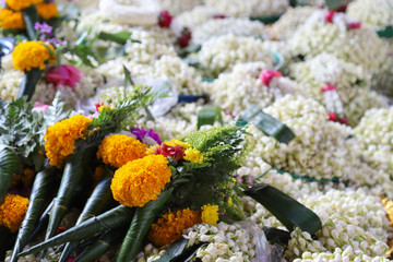 Closeup of colorful marigold and jasmine flowers used for giving respect.