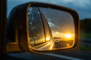 car on highway. sunset in car mirror reflection