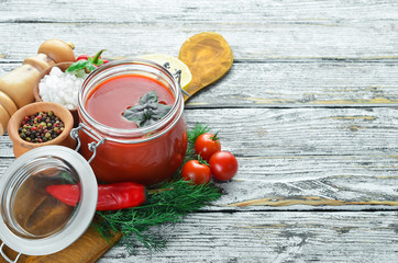 Tomato paste Ketchup with vegetables, homemade. Top view. On a white wooden background. Free space for text.