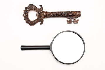 Vintage rusty key and magnifier isolated on white background