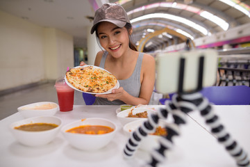 Young beautiful woman vlogging with mobile phone in restaurant