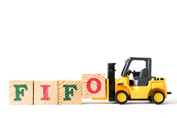 Toy forklift hold letter block  to complete word FIFO (Abbreviation of first in first out) on white background