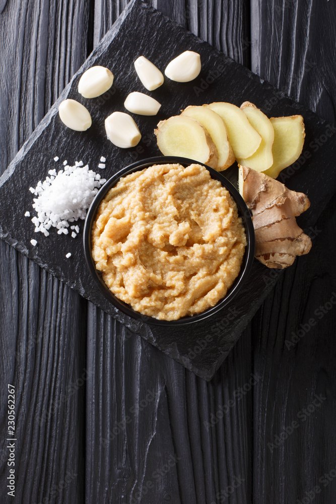 Sticker Fresh Ginger and Garlic paste or Adrak Lahsun puree in a ceramic bowl. Vertical top view