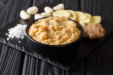 Ginger Garlic paste Fresh mashed Adrak and Lahsun in bowl and whole. black background. Horizontal