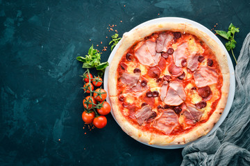 Pizza with bacon and sausages. Italian traditional dish. On the old background. Top view. Free...