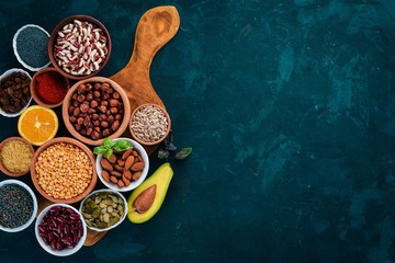 Superfoods Healthy food. Nuts, berries, fruits, and legumes. On a black stone background. Top view. Free copy space.