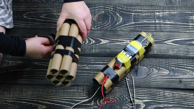 process of making an explosive device, on a dark wooden background.