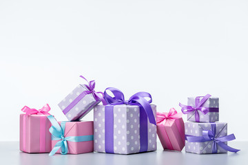 Set of different boxes in elegant paper, decorated with ribbons and bows on light background.