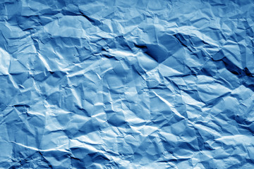 Crumpled sheet of paper with blur effect in navy blue tone.