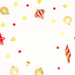 Christmas frame composition of golden and red decorations with confetti on white background. Flat lay, top view, copy space