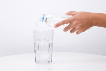 Hand Pouring water from a bottle in to a glass